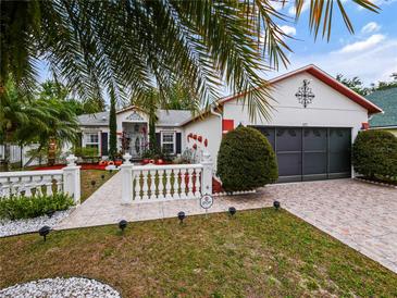 Charming home featuring a decorative fence, well-manicured lawn, and a two-car garage at 572 Nogales Ct, Kissimmee, FL 34758