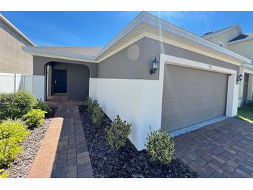Charming single-Gathering home with a well-manicured landscape and a two-car garage with brick paver driveway at 939 Anna Pl, Davenport, FL 33837