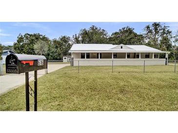 Inviting single-story home featuring a large, charming front porch and well-maintained lawn with a metal roof at 616 Se 31St Ter, Ocala, FL 34471