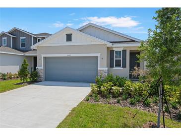 Charming single-Gathering home with a gray garage door and stone accents on the front facade at 6397 Clover St, Lake Hamilton, FL 33851