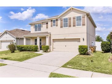 Two-story home with a two car garage, well-maintained lawn and shuttered windows at 1907 Partin Terrace Rd, Kissimmee, FL 34744
