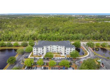 Apartment complex with lush greenery, parking, and lakeside views offers a serene living environment at 3176 Feltrim Pl # 202, Kissimmee, FL 34747