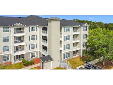 Three-story apartment building featuring balconies and manicured landscaping in a serene neighborhood at 3176 Feltrim Pl # 202, Kissimmee, FL 34747