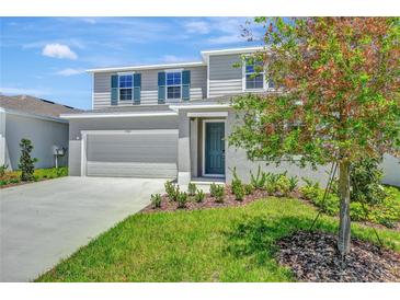 Charming two-story home with a well-maintained lawn, lovely landscaping, and a two car garage at 1745 Carnelian St, Deland, FL 32720