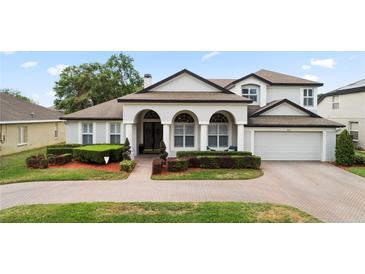 Charming two-story home featuring a brick driveway, manicured landscaping, and elegant architectural details at 3852 Brantley Place Cir, Apopka, FL 32703