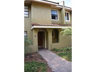 Charming two-story townhouse with a welcoming brick walkway, arched entry, and well-maintained landscaping at 1122 Spaceport Ct, Kissimmee, FL 34741