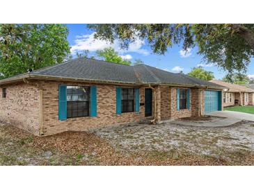 Charming brick home with blue shutters and a well-maintained lawn provides excellent curb appeal at 2081 N Normandy Blvd, Deltona, FL 32725
