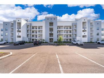 Apartment building showcasing a modern design with white and gray accents against a bright blue sky at 3120 Paradox Cir # 302, Kissimmee, FL 34746