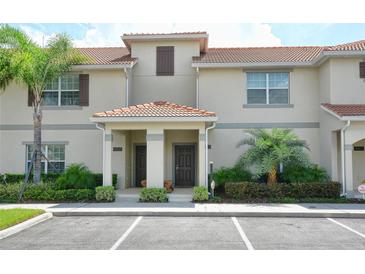 Charming townhouse with a red tile roof, neutral exterior, and well-maintained landscaping at 4888 Romeo Cir, Kissimmee, FL 34746