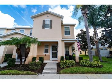 Inviting two-story home with well-manicured landscaping and an American flag, presenting a charming curb appeal at 5101 Staniard Dr, Kissimmee, FL 34746