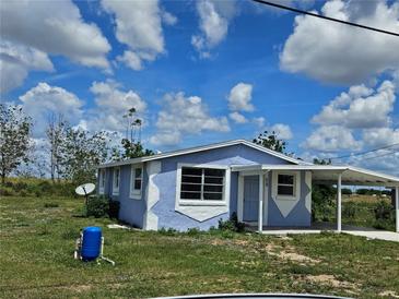 Charming single-story home with carport and uniquely painted exterior at 58 Lincoln St, Frostproof, FL 33843
