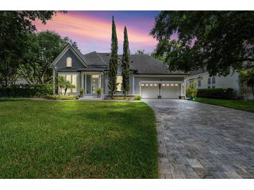 Charming home with a well-manicured lawn, mature trees, and a brick driveway at 8374 Bowden Way, Windermere, FL 34786