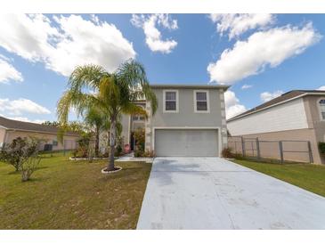 Charming two-story home featuring a well-maintained front yard with a palm tree and inviting curb appeal at 905 Gloucester Ct, Kissimmee, FL 34758