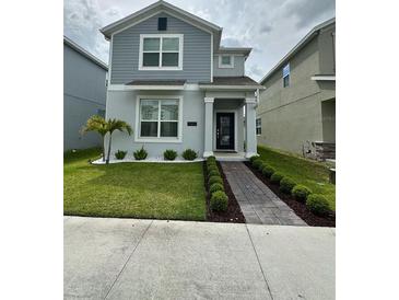 Charming two-story home with a well-manicured lawn, tidy landscaping, and a welcoming walkway at 11312 Listening Dr, Orlando, FL 32832