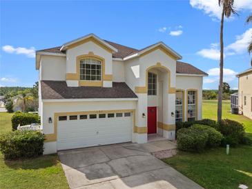 Charming two-story home featuring a red door, neutral stucco exterior, and an attached two car garage at 107 Troon Cir, Davenport, FL 33897