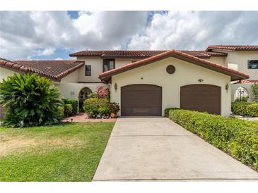 Charming townhome with a well-manicured lawn, mature landscaping, and a two-car garage at 117 Coventry Ln, Haines City, FL 33844
