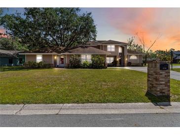 Charming two-story home with manicured lawn, lush landscaping, and brick mailbox on a sunny day at 1730 King Henry Dr, Kissimmee, FL 34744