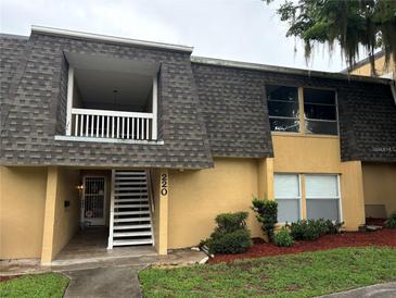Inviting two-story condo featuring stairs to the front entry and second level porch at 220 E Desoto St # C, Clermont, FL 34711