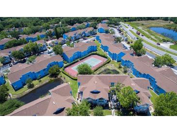 A vibrant apartment community offers a tennis court and lush landscaping near a tranquil pond at 2725 N Poinciana Blvd # 147, Kissimmee, FL 34746