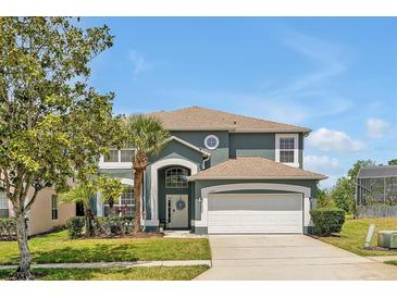 Charming two-story home featuring a two-car garage, well-manicured lawn, and mature landscaping at 2747 Lido Key Dr, Kissimmee, FL 34747