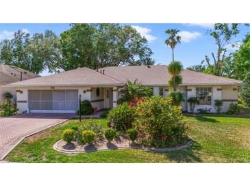 Charming one-story home with well-manicured landscaping and a brick-paved driveway at 5137 Links Ln, Leesburg, FL 34748