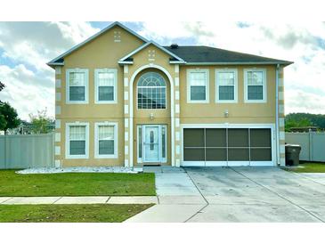 Two-story home featuring a two-car garage and a manicured lawn at 7716 Park Hill Ave, Leesburg, FL 34748