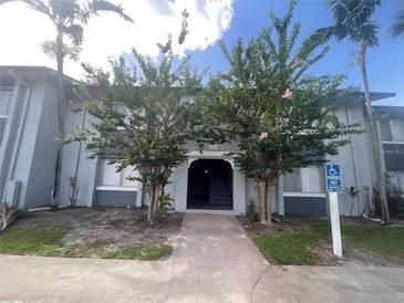 Two-story condo building featuring well-kept landscaping, a sidewalk and palm trees at 4745 S Texas Ave # A, Orlando, FL 32839