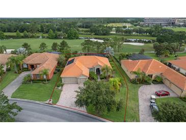 Lovely aerial view of a home with terra cotta roof, an attached two-car garage, and a beautifully landscaped yard at 133 Torino Ln, Kissimmee, FL 34759