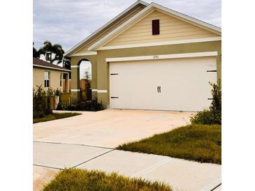 A two-car garage with a concrete driveway enhances the exterior of this single-Gathering home at 1791 Post Oak Dr, Davenport, FL 33837