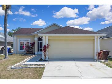 Charming single-story home featuring a two-car garage and colorful landscaping at 2049 Shannon Lakes Blvd, Kissimmee, FL 34743