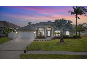 Charming home with arched entryway, well-manicured lawn, and lush palm trees at 3037 Diamond Ln, St Cloud, FL 34772