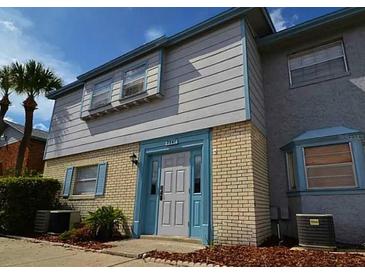 Two-story townhouse featuring light gray siding and a brick base, complemented by a blue trim at 7341 Daniel Webster Dr # 4, Winter Park, FL 32792