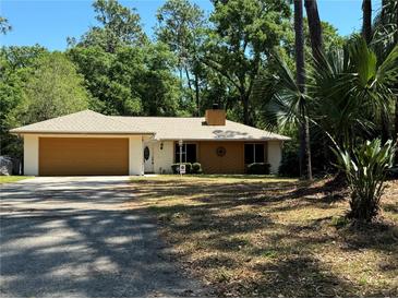 Charming single-story home with a two-car garage, manicured lawn and mature landscaping at 805 Hemlock Dr, Apopka, FL 32712