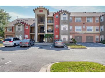 Condominium building featuring ample parking and convenient access to units via exterior stairs at 2203 Key West Ct # 432, Kissimmee, FL 34741