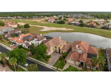 Stunning aerial view of a beautiful home overlooking a golf course, lake, and lush neighborhood at 2234 Callaway Ct, Davenport, FL 33837