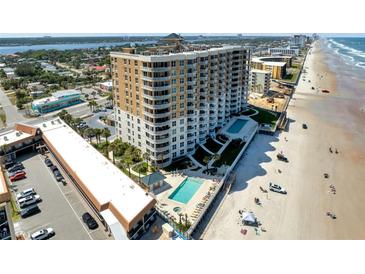 Stunning aerial view of a beachfront high-rise with pools and a beautiful sandy beach at 2403 S Atlantic Ave # 501, Daytona Beach Shores, FL 32118
