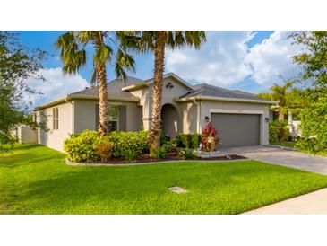 Charming single-story home with a well-manicured lawn, lush landscaping, and a two-car garage at 4007 Green Sabal Dr, Orlando, FL 32824