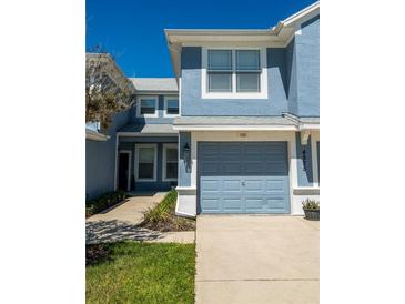 A charming two-story home features a light blue exterior, attached garage, and well-maintained landscaping at 4525 Sw 52Nd Cir # 103, Ocala, FL 34474