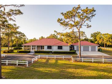 Charming home featuring a red roof, a large front yard, and a white fence at 4561 Henry J Ave, St Cloud, FL 34772