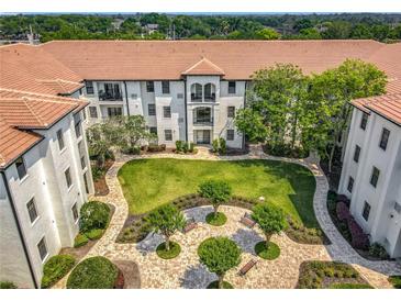 Stunning aerial view of condo complex showcasing lush courtyard and Spanish tile roof at 5550 E Michigan St # 2214, Orlando, FL 32822