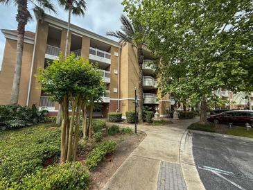 Inviting exterior view of the property showing the multiple balconies and landscaped walkway at 7658 Whisper Way # 203, Reunion, FL 34747
