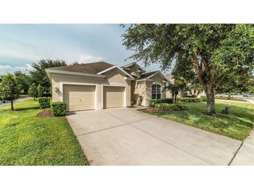 Charming single-story home featuring a two-car garage, well-manicured lawn, and mature landscaping at 7719 Comrow St, Kissimmee, FL 34747