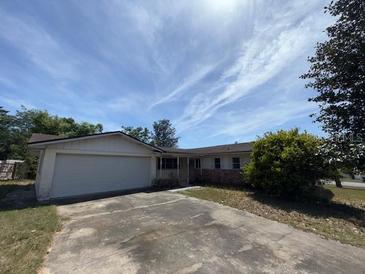 Single-story home with an attached two-car garage and a driveway in front, under a bright sky at 8 Emerald Way, Ocala, FL 34472