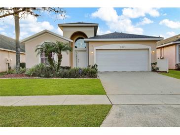 Charming single-story home with a two-car garage, well-manicured lawn, and decorative landscaping at 932 Emerald Green Ct, Kissimmee, FL 34746