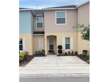 Charming townhouse featuring a well-maintained front yard and neutral color palette at 4871 Coral Castle Dr, Kissimmee, FL 34746