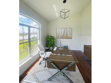 Bright and modern home office space with a large window overlooking a serene view and stylish decor at 738 Leonardo Ct, Kissimmee, FL 34758