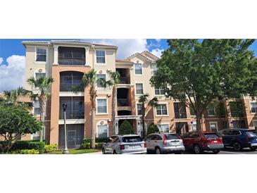 Beautiful condo building with palm trees, manicured landscaping, and convenient parking for residents and guests at 8296 Portofino Dr # 401, Davenport, FL 33896