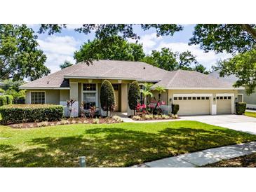Charming ranch-style home featuring a three-car garage and mature landscaping for enhanced curb appeal at 9509 Baycliff Ct, Orlando, FL 32836