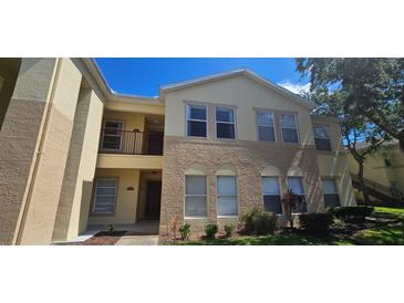 Inviting multi-level condo featuring a mix of neutral colors and well-maintained landscaping under a clear blue sky at 2804 Club Cortile Cir # A, Kissimmee, FL 34746