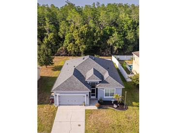 Charming single Gathering home with gray roof, lush green front yard, and convenient two car garage at 3633 Bristol Cove Ln, St Cloud, FL 34772